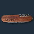 Load image into Gallery viewer, Against a dark background rests The Ultimate Gift for Him, a sleek pocket tool with an engraved wooden handle reading JARED. This versatile 8-function multi-tool, including a corkscrew, offers customizable engraving for a personal touch.