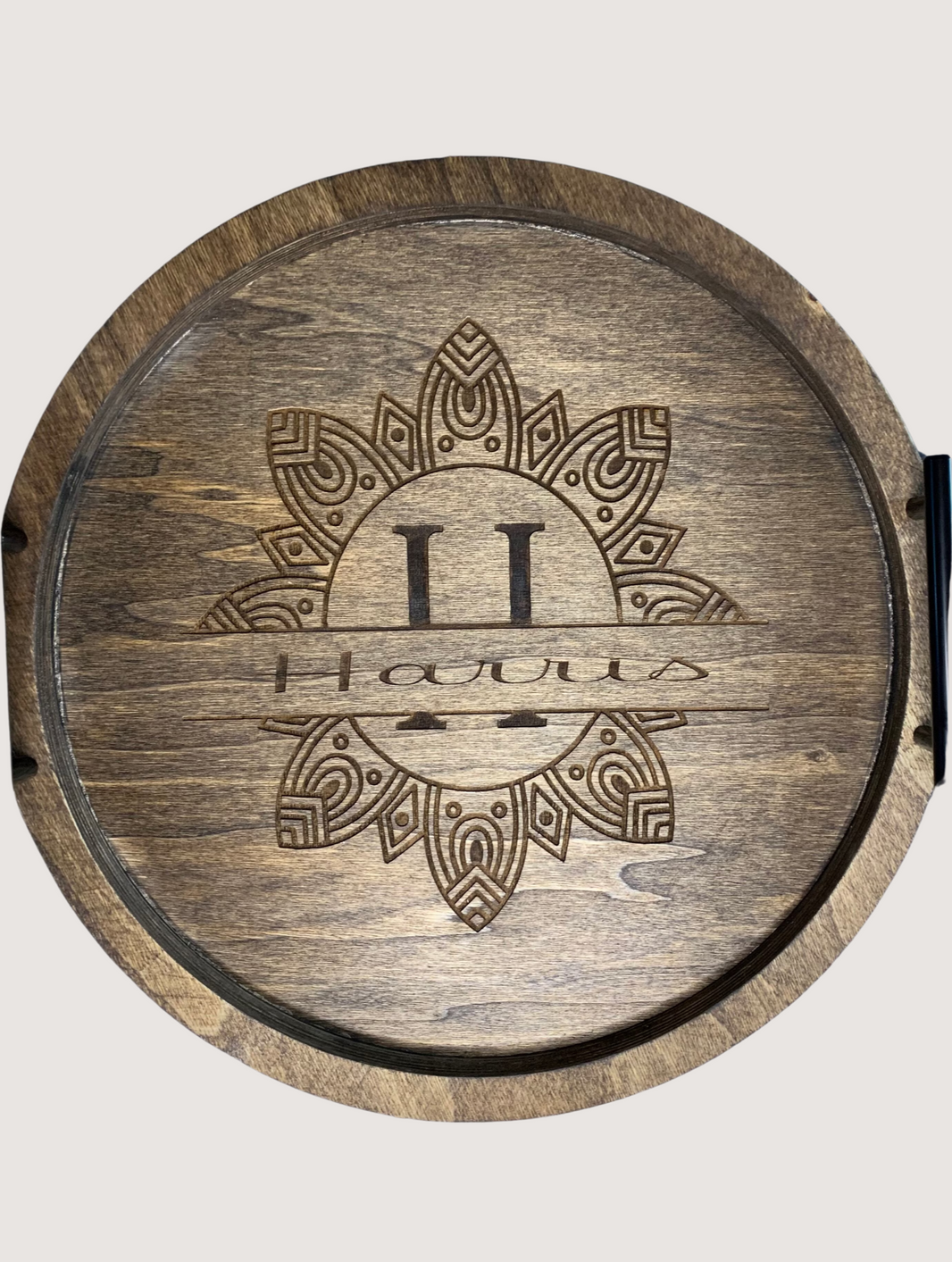 Round wooden Boho style monogram serving tray. Monogram and last name is engraved while the tray is stained. Black mbar handles.